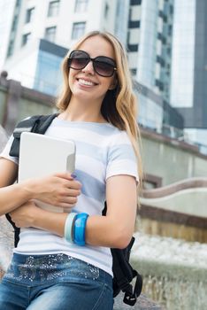 Young pretty girl student at river front with tablet pc in hands
