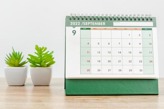 September 2022 desk calendar on wooden background.