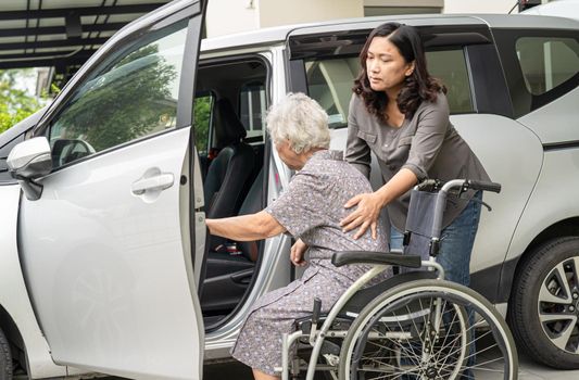Caregiver daughter help and support asian senior or elderly old lady woman patient prepare get to her car.