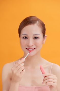 Woman putting on lip gloss
