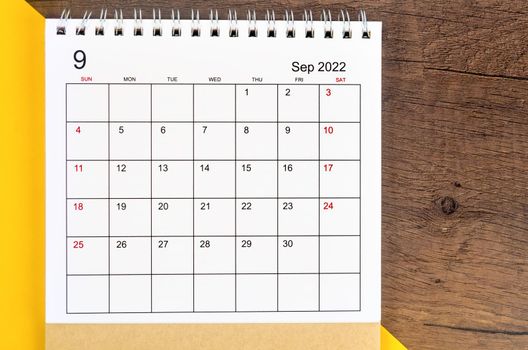 September 2022 desk calendar on wooden background.