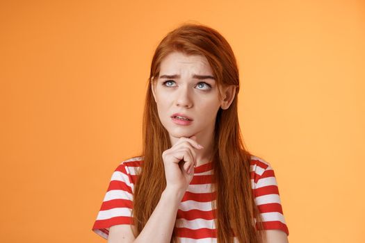 Perplexed redhead woman trying make calculations mind, frowning focused, look up puzzled thoughtful, touch chin, thinking, pondering important decision, make choice, solve problem