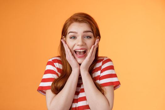 Close-up cute redhead cheerful girl look amazed yelling from joy lucky achieve best score, got scholarship, woman receiving stunning news, unbelievable success, smiling broadly, touch cheeks