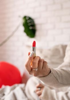 woman hand holding red lipstick