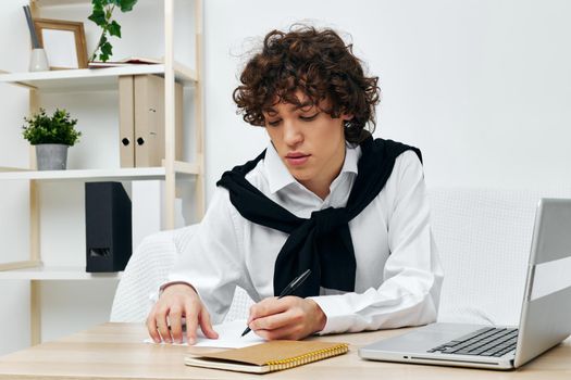 curly guy laptop sitting on white sofa online training communication. High quality photo