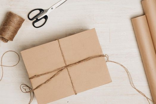 Cardboard carton wrapped with brown paper and tied with string