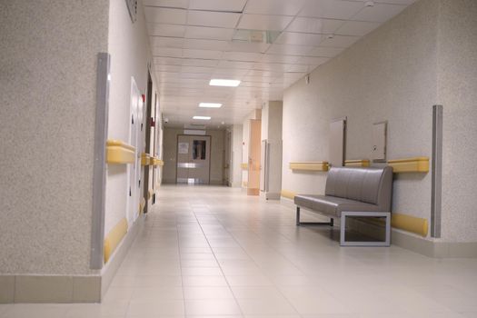 An empty long gray corridor of an building, nobody