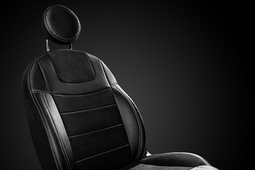 Comfortable front car seat back with round headrest on black background