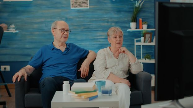 Retired grandparents having fun with comedy on television