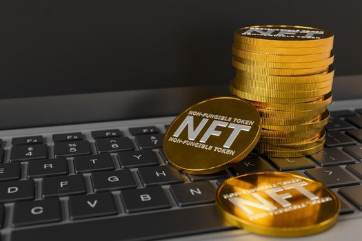 NFT coins stacked on top of a laptop keyboard