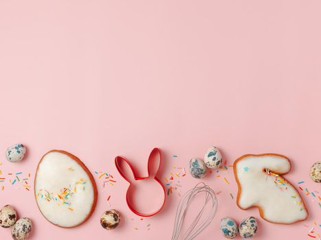 Easter cooking baking concept. Easter cookie cutter on pink pastel background. Happy Easter Day concept. Easter cookie cutters and cookies, colorful eggs over pink background. Copy space for text. Top view or flat lay