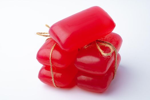 Red handmade soap bars tied with ribbon on white background
