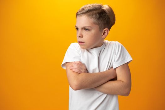 Portrait of naughty little boy against yellow background