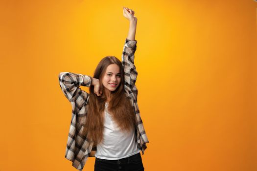 Teen Girl waking up and stretching against yellow background