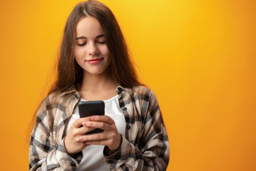 Portrait of a smiling young girl using smartphone