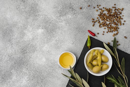 Olives and spices on a gray stone background