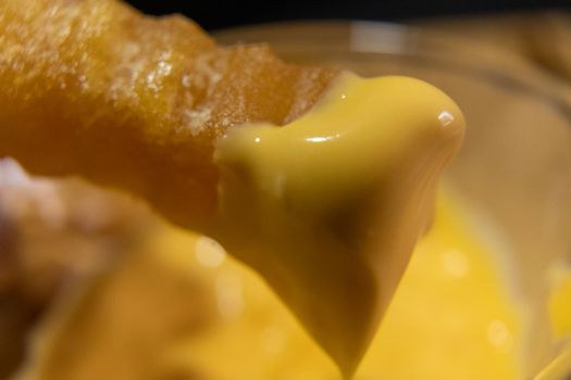 Close-up of delicious melted cheese on wavy French fry