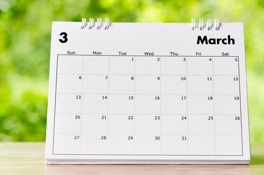 March 2022 Calendar desk for organizer to plan and reminder on wooden table