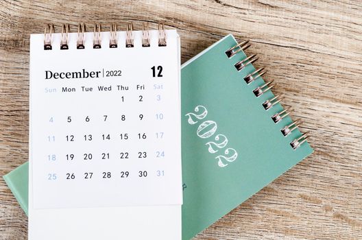 December 2022 desk calendar on wooden table.