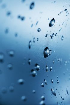 Drops of clean water on the glass. Blue background