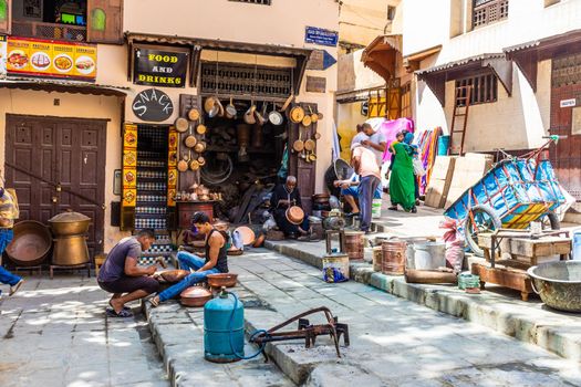 FEZ, MOROCCO, 15 AUGUST 2018: People in their traditional activity of crafting with copper in the medina