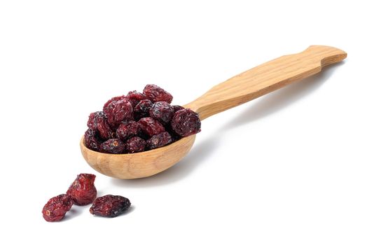 bunch of dried cranberries in a wooden spoon on a white background. Delicious berry