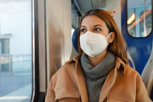 Business woman wearing protective mask while traveling by public transportation