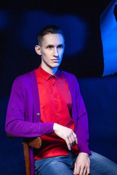 Stylish man in red shirt in dark studio