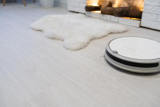 Automated vacuum cleaning robot powered by rechargeable battery in modern living room