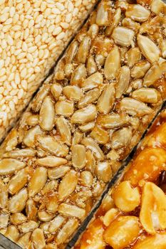 Assorted kozinaki, sweets from sunflower seeds, sesame and peanuts filled with brilliant glaze. Macro