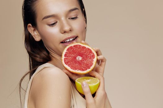 woman grapefruit near face clean skin care health beige background
