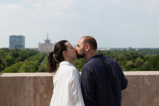 Married happy couple kissing on tower rooftop
