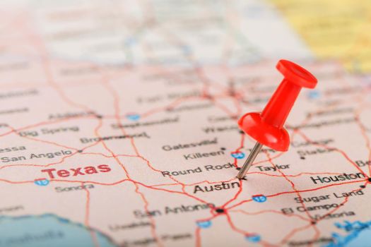 Red clerical needle on a map of USA, Texas and the capital Austin. Closeup Map Texas with Red Tack