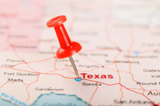 Red clerical needle on a map of USA, Texas and the capital Texan. Close up map of Texas with red tack