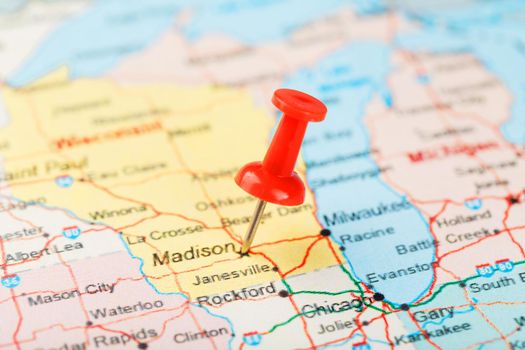 Red clerical needle on a map of USA, Michigan and the capital Lansing. Close up map of Michigan with red tack