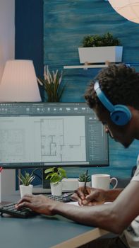 Person working with sketch of blueprint plan on computer