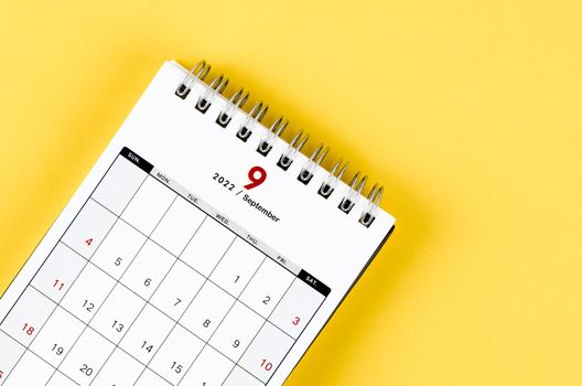 September 2022 desk calendar on yellow background.