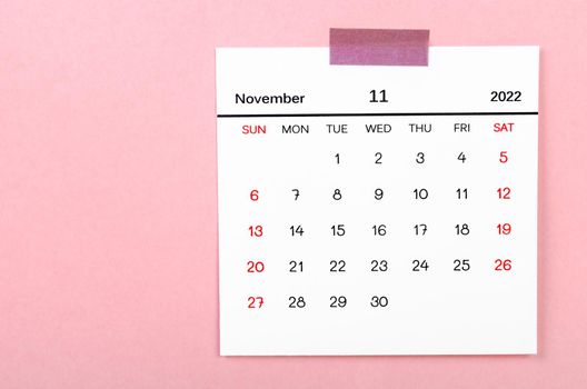 November 2022 calendar on pink background.
