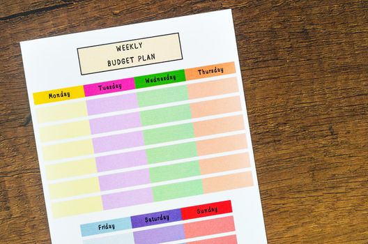 Weekly budget plan form on wooden