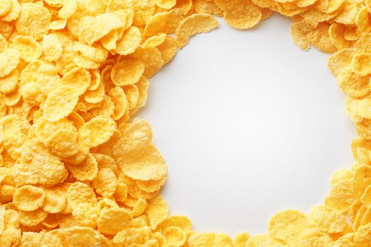 Golden cornflakes on full frame with empty white space. Healthy breakfast