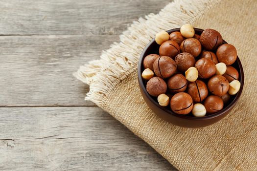 Macadamia nut on wooden background with vintage cloth, concept of superfoods and healthy food