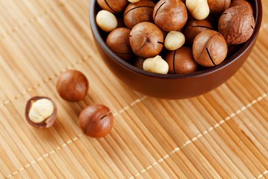 Macadamia nut on bamboo texture, concept of superfoods and healthy food