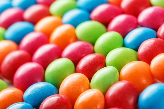 Rainbow colors of multicolored candies close-up, texture and repetition of dragee