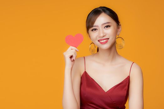 Woman holding paper heart shaped card 