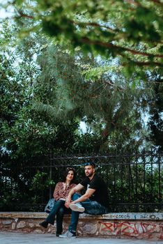 Athens, Greece, May 21, 2019: Park outdoor, young, loving couples relaxing on benches, editorial