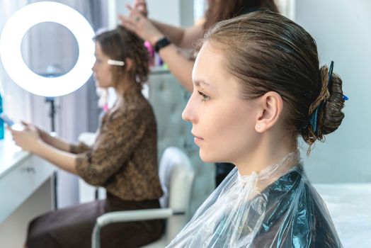 hair coloring in a beauty salon, young girl during dyeing process
