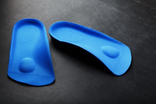 Orthopedic insoles for correction of pronation of the foot on a dark background.