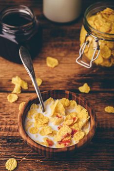 Breakfast with corn flakes, milk and syrup