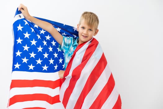 Blonde boy waving national USA flag outdoors over white background. American flag, patriotism, independence day 4th july concept