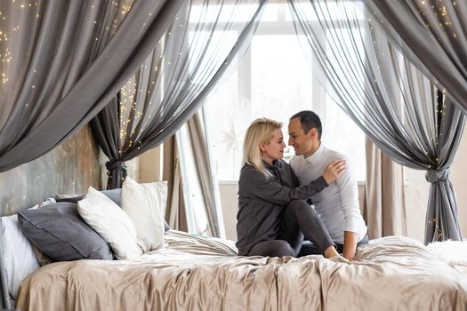 Cheerful couple awaking and looking at each other in bed